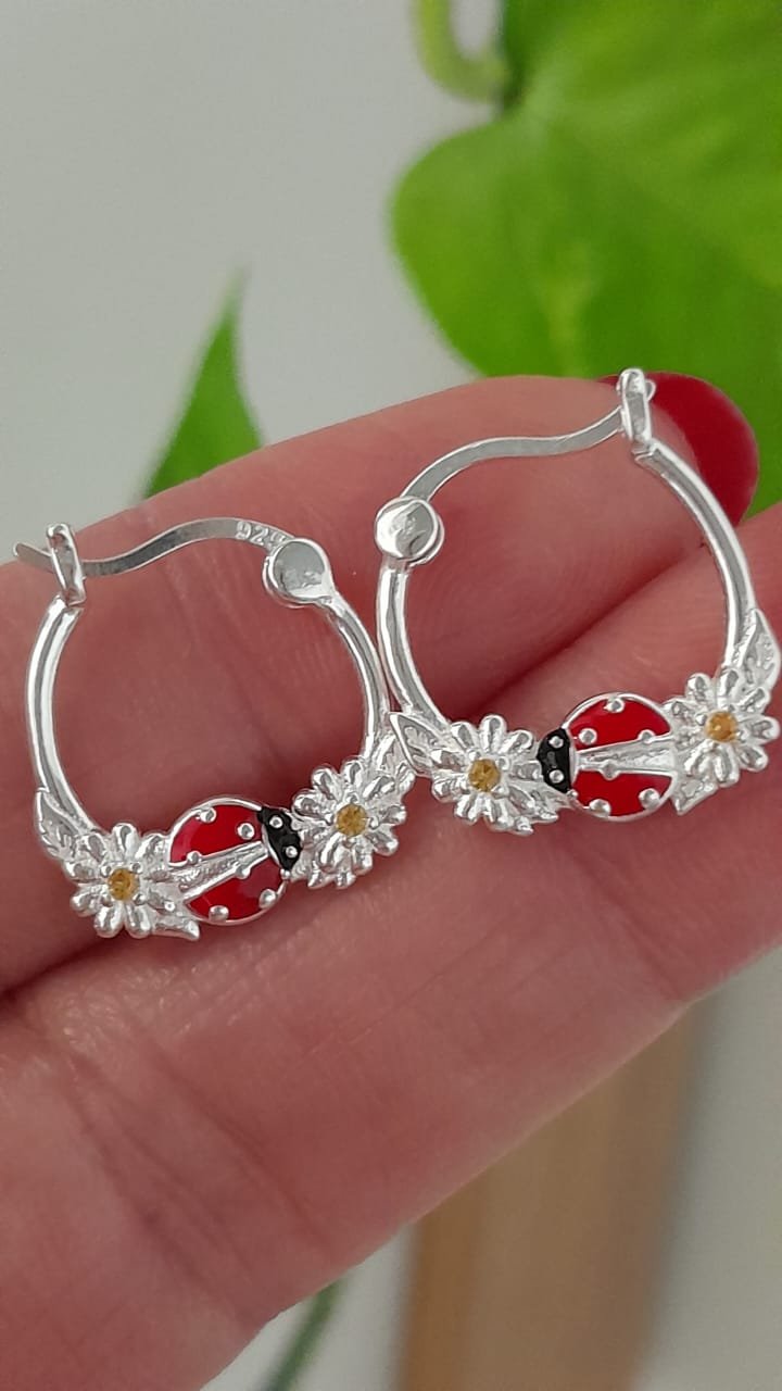 Aros cierre huggies esmaltado vaquita y margaritas - Plata 925