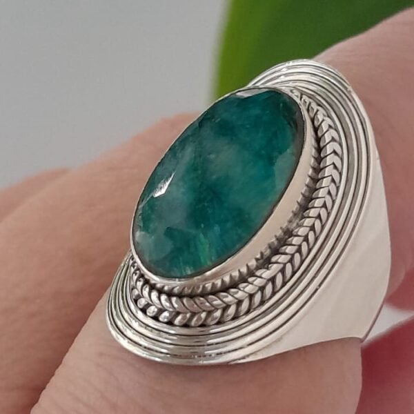 Anillo de plata 925 con un engarce detallado y una piedra central de raíz de esmeralda