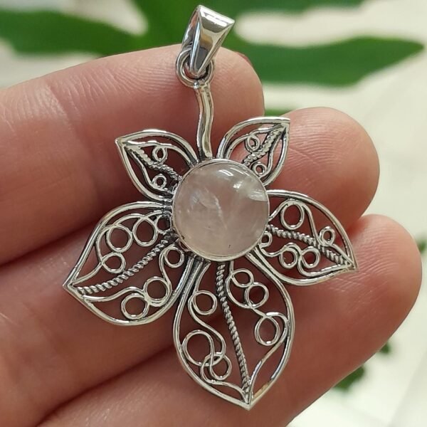 Colgante de plata con diseño floral y un cuarzo rosa natural en el centro
