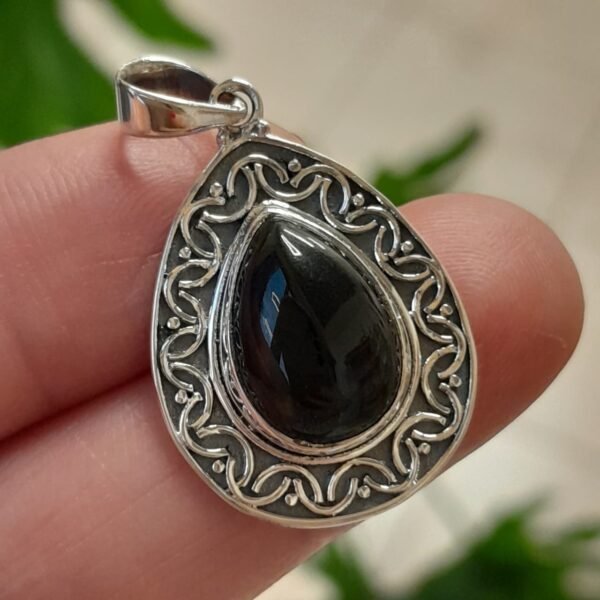 Dije de gota de ónix negro engastado en plata con un detallado borde de filigrana